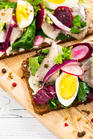 Pickled Marinated Herring and Beetroot Open Sandwich on Rye Bread. Traditional Danish Smorrebrod. Selective focus.の写真素材