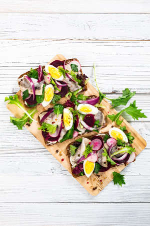 Pickled Marinated Herring and Beetroot Open Sandwich on Rye Bread. Traditional Danish Smorrebrod. Selective focus.の写真素材