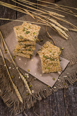 Multigrain Cereal Crunchy Squares Bars with Pumpkin Seeds Background. Healthy Bar Snack. Selective focus.の写真素材