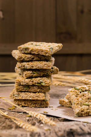 Multigrain Cereal Crunchy Squares Bars with Pumpkin Seeds Background. Healthy Bar Snack. Selective focus.の写真素材