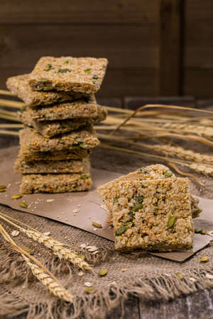 Multigrain Cereal Crunchy Squares Bars with Pumpkin Seeds Background. Healthy Bar Snack. Selective focus.の写真素材
