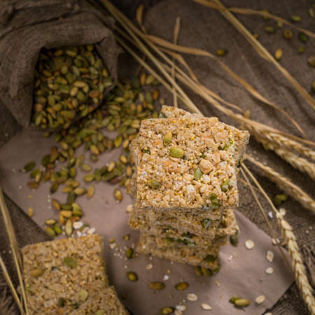 Multigrain Cereal Crunchy Squares Bars with Pumpkin Seeds Background. Healthy Bar Snack. Selective focus.の写真素材
