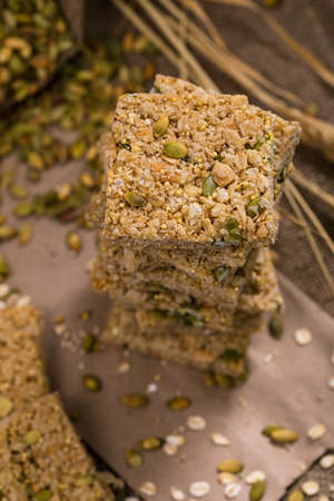 Multigrain Cereal Crunchy Squares Bars with Pumpkin Seeds Background. Healthy Bar Snack. Selective focus.の写真素材