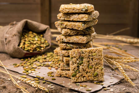 Multigrain Cereal Crunchy Squares Bars with Pumpkin Seeds Background. Healthy Bar Snack. Selective focus.の写真素材
