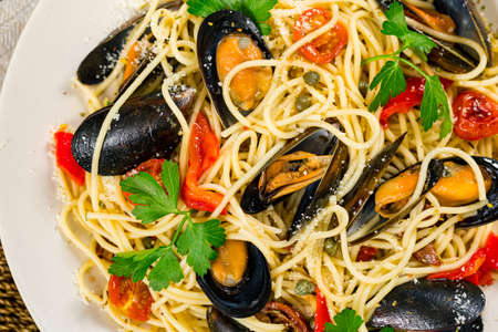 Seafood Pasta Spaghetti with Mussels and Tomatoes on Wooden Background. Italian Cuisine. Selective focus.の写真素材