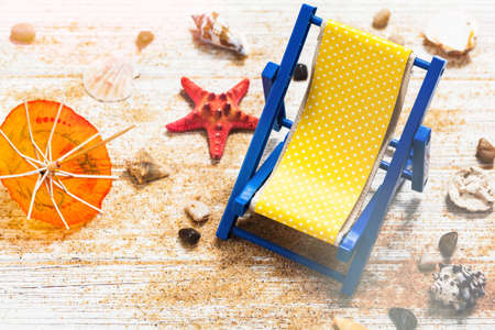 Beach Chair, Shells, Sand on white wooden board background card concept. Selective focus.の写真素材