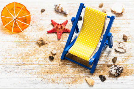 Beach Chair, Shells, Sand on white wooden board background card concept. Selective focus.の写真素材