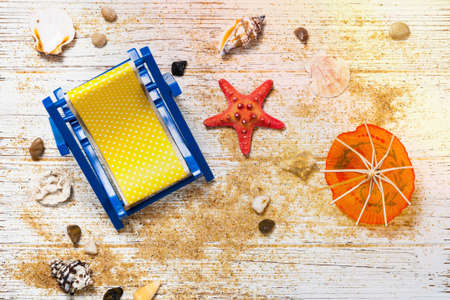 Beach Chair, Shells, Sand on white wooden board background card concept. Selective focus.の写真素材