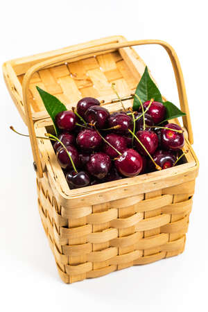 Cherries in a Wicker Basket on a White Background. Selective focus.の写真素材