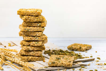 Multigrain Cereal Crunchy Squares Bars with Pumpkin Seeds on Wooden Background. Selective focus.の写真素材