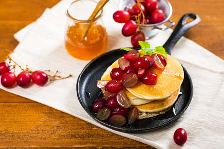 Stack of Pancakes with Sliced Red Grapes and Maple Syrup. Selective focus.の写真素材