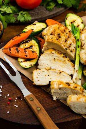 Grilled Chicken Breasts with Grilled Vegetables Zucchini and Carrot Background. Selective focus.の写真素材