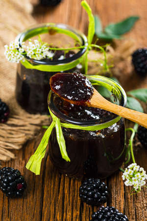 Jar of Blackberry Jam Preserves on Old Wooden Background. Selective focus.の写真素材