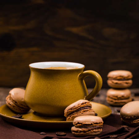 Dark Chocolate Macaron with Coffee Beans on Wooden Table. Selective focus.の写真素材
