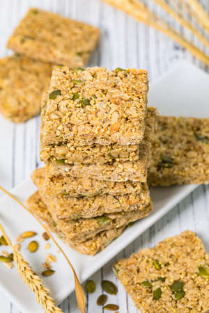 Multigrain Cereal Crunchy Squares Bars with Pumpkin Seeds Background. Healthy Bar Snack. Selective focus.の写真素材