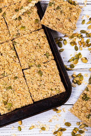 Multigrain Cereal Crunchy Squares Bars with Pumpkin Seeds Background. Healthy Bar Snack. Selective...