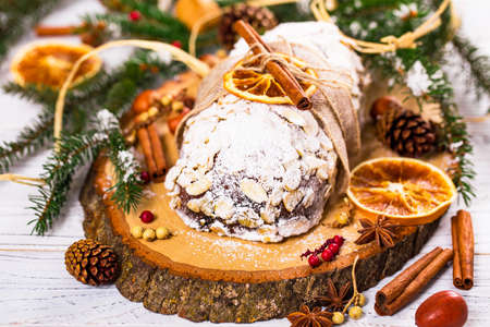Christmas Holiday Background. Stollen, German Christmas Cake with Dried Fruits and Sliced Almonds Nuts. Selective focus.の写真素材