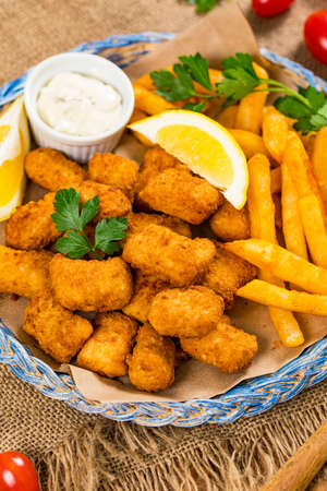 Crispy Fish Bites Snack Size. Deep Fried Pollock Fish Fingers with Tartar Dipping Sauce. Selective focus.の写真素材