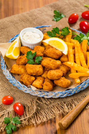 Crispy Fish Bites Snack Size. Deep Fried Pollock Fish Fingers with Tartar Dipping Sauce. Selective focus.の写真素材