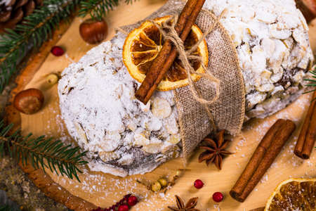 Christmas Holiday Background. Stollen, German Christmas Cake with Dried Fruits and Sliced Almonds Nuts. Selective focus.の写真素材