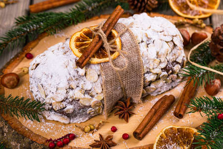 Christmas Holiday Background. Stollen, German Christmas Cake with Dried Fruits and Sliced Almonds Nuts. Selective focus.の写真素材