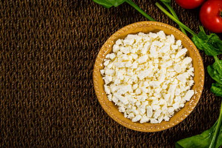 Feta Crumbled Cheese with Spinach and Tomatoes Background. Selective focus.の写真素材