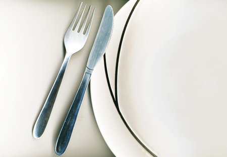 knife and fork with modern dinner plate on white