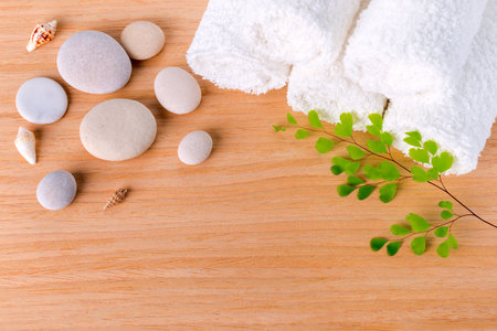 Spa concept with stacked of stone, shell, branch and towelの写真素材