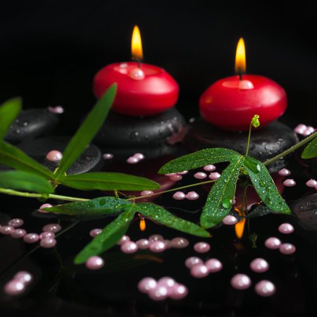 spa still life of passiflora branch, pearl beads and red candles on zen stones with reflection in water, closeup の写真素材
