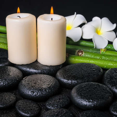 spa concept of zen basalt stones, two white flower frangipani, candles and natural bamboo with drops, closeup の写真素材