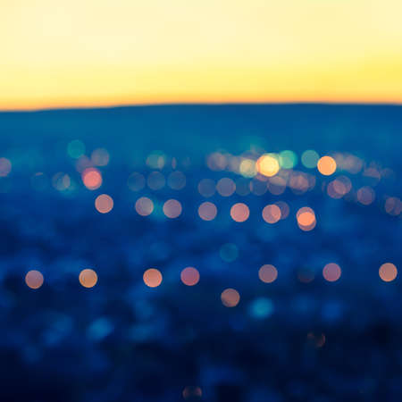 city blurring lights abstract circular bokeh blue background with twilight horizon, closeupの写真素材