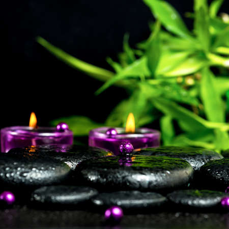 spa still life of zen basalt stones with drops, lilac candles, beads and bamboo, closeupの写真素材