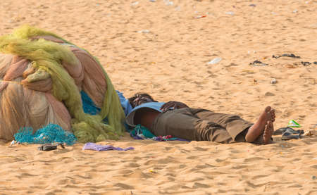 CHENNAI, INDIA - FEBRUARY 10: An unidentified man sleeps on the sand near the Marina Beach on February 10, 2013 in Chennai, India.のeditorial素材