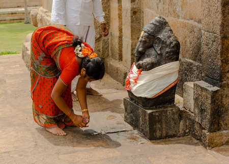 THANJAVUR, INDIA - FEBRUARY 13: Indian woman  in national costume brings offerings to Ganesha at Gangaikonda Cholapuram Temple. India, Tamil Nadu, Thanjavur (Trichy). February 13, 2013.のeditorial素材