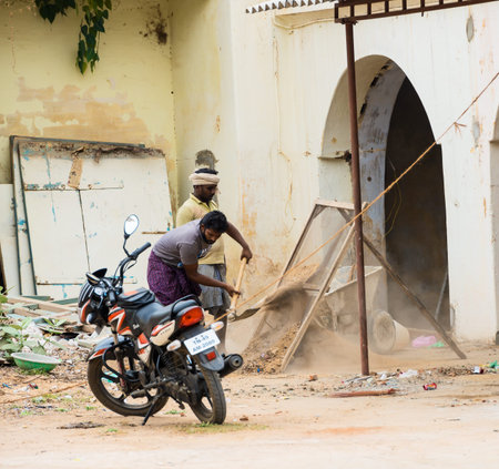 THANJAVOUR, INDIA - FEBRUARY 14: An unidentified Indian man sifts sand. India, Tamil Nadu,...