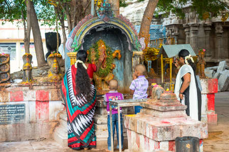 MADURAI, INDIA - FEBRUARY 16: An unidentified boys and woman in traditional Indian dress are commiting ritual actions. India, Tamil Nadu, Madurai. February 16, 2013のeditorial素材