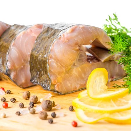 raw fillet steak of sturgeon fish with greens, lemon, different peppers and salt, isolated on white...