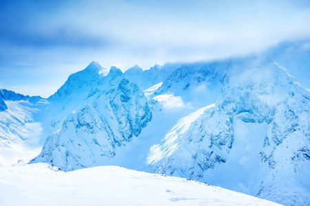 beautiful landscape winter snow covered of Dombaj mountain peaks with clouds and valley, close up