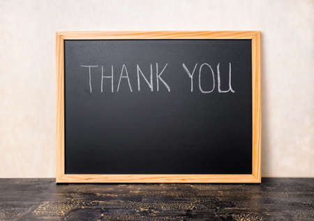 handwriting text thank you is written in chalkboard on craquelure black board, close upの写真素材