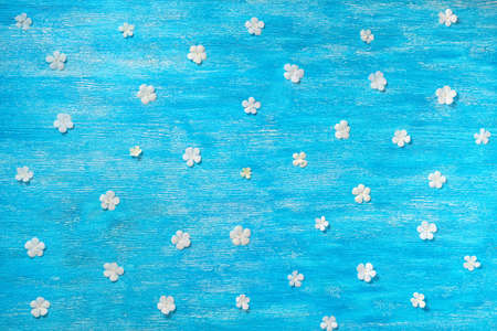 flat lay of beautiful trendy seamless pattern white flowers on blue wooden background, close upの写真素材