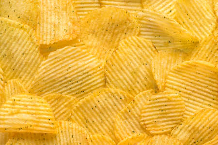 rippled natural potato chips with salt and greenery like backgroundの写真素材