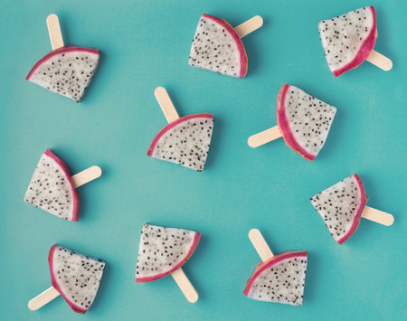 beautiful fresh sliced popsicles dragon fruit like background, Pitaya, flat lay on blue background