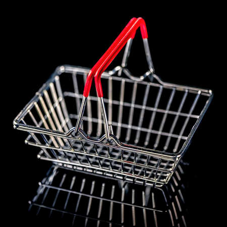 concept of black friday advert sale empty metal shopping basket isolated on black background, close upの写真素材