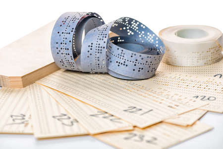 still life of perforated punched tapes and card with old data isolated on white background, close up still life of perforated punched tapes and card with old data isolated on white background, close up