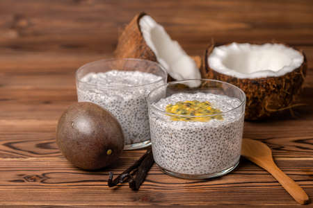 chia pudding in glass, decorated  vanilla pods, passionfruit and coconuts on wooden background, healthy detox lifestyle conceptの写真素材