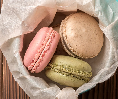 top view of french dessert macarons cake in gift box on wooden background, close up
