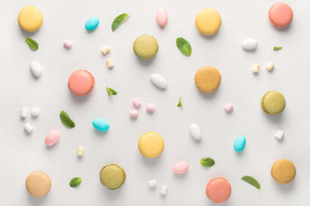 Flat lay of colorful macarons cookies and candies like background, pastel colorsの写真素材