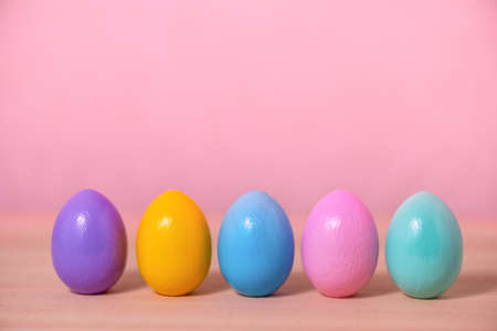 row multi colored painted Easter eggs over pink background, festive greeting card の写真素材