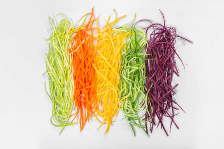 flat lay of mix red, yellow, orange carrots and cucumber finely julienned vegetables for salad, concept healthy eatingの写真素材