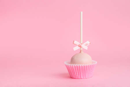 single festive icing cake pop over pink background, close upの写真素材